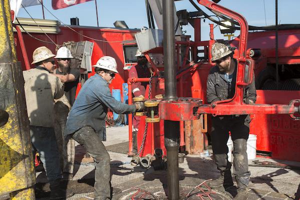 Drill floor crew working pipe on Rig 15